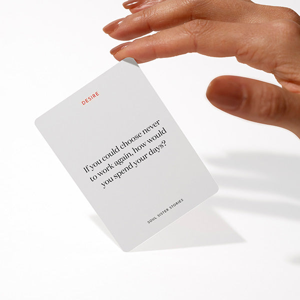 Hand holding a card. Text on card says If you could choose never to work again, how would you spend your days?