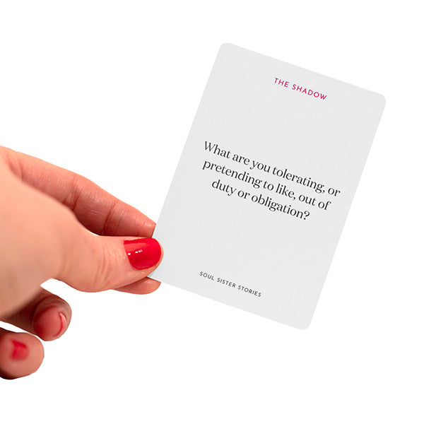 Hand holding a card. Text on card says What are you tolerating or pretending to like, out of duty or obligation