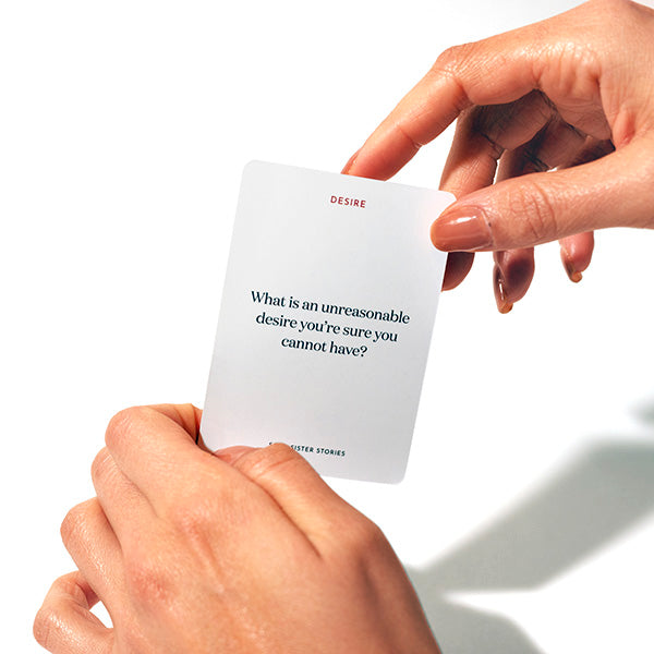 Hand hold a card. Text on card; What is an unreasonable desire you're sure you cannot have?